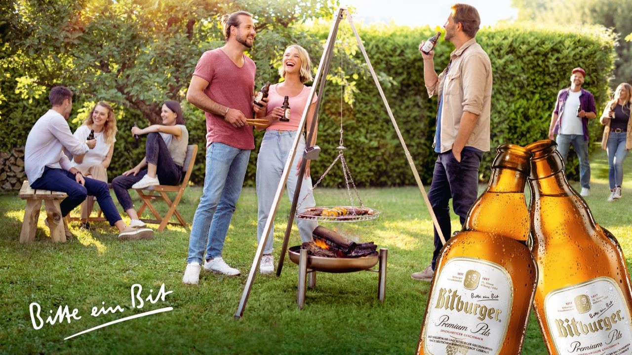 Le modelle SHOWCAST in una campagna pubblicitaria Bitburger presentano un prodotto durante una festa in giardino.